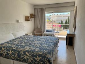 a bedroom with a bed and a view of a balcony at Hostal Roberto in Palmanova +114 photos