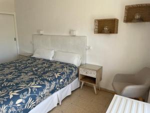 a bedroom with a bed with a blue and white bedspread at Hostal Roberto in Palmanova