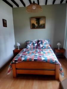 a bedroom with a bed with a colorful comforter at Au cerisier in Saint-Maulvis