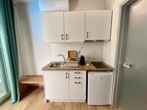 a small kitchen with white cabinets and a sink at ΑVLI Sarti Superior Studio no5 in Sarti