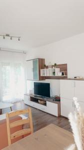 a living room with a tv and a table at Gacka idila in Otočac