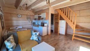 a living room with a couch and a staircase in a cabin at Gazdówka in Gródek Nad Dunajcem