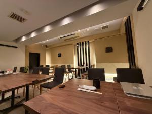 a conference room with wooden tables and chairs at Haniwa Stay Josai in Nagoya
