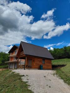 a log cabin with a roof on a dirt road at A-frame Đukić in Jajce
