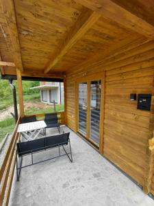 a patio with two chairs and a bench at A-frame Đukić in Jajce +1 photo