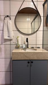 a bathroom with a sink and a mirror at Chale Pedra do Sol in Caxias do Sul