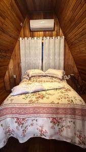 a bedroom with a bed in a wooden room at Chale Pedra do Sol in Caxias do Sul