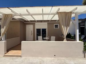 a pergola on a house with a table and chairs at ΑVLI Sarti Superior Studio no5 in Sarti