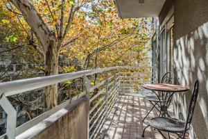 a balcony with a table and chairs and a tree at Color Botánico in Buenos Aires