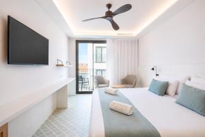 a hotel room with a bed and a flat screen tv at Neptuno Hotel & SPA 4 Sup in Calella