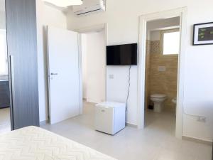 a white room with a toilet and a television at Guest House Maramà in Belvedere Marittimo