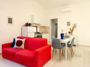 a living room with a red couch and a table at Guest House Maramà in Belvedere Marittimo