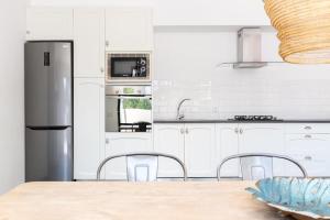 a kitchen with white cabinets and a stainless steel refrigerator at Villa Palma - Establiments by PriorityVillas in Palma de Mallorca