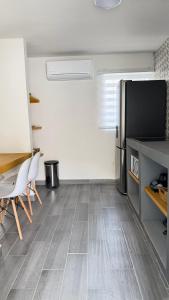 a living room with a table and a refrigerator at Loft-LunaRoja in Montemorelos