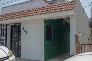 a house with a white door and a green wall at Loft-LunaRoja in Montemorelos