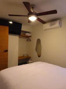 a bedroom with a bed and a ceiling fan at Loft-LunaRoja in Montemorelos