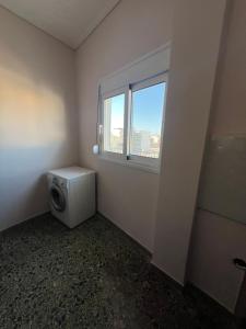 ein Badezimmer mit Waschmaschine und Fenster in der Unterkunft Light Apartment in Ierápetra