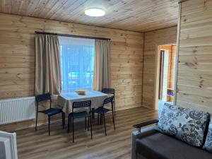 a dining room with a table and chairs and a couch at Welcome to Карпати in Skole