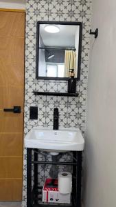 a bathroom with a white sink and a mirror at Loft-LunaRoja in Montemorelos +9 photos