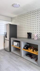 a kitchen with a stainless steel refrigerator in a room at Loft-LunaRoja in Montemorelos
