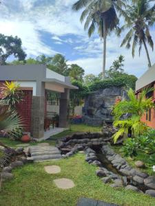 a backyard with a pathway and a house at Aruvi on the cliff in Varkala
