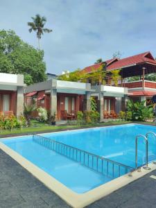 a resort swimming pool in front of a building at Aruvi on the cliff in Varkala