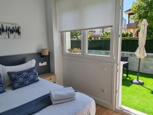 a bedroom with a bed and a window at Alojamientos Dima Costa in Laredo