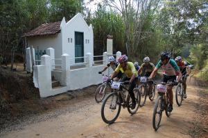 a group of people riding bikes down a dirt road at Pousada Primavera in São Luiz do Paraitinga