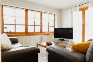 a living room with two couches and a flat screen tv at Arches in Agria