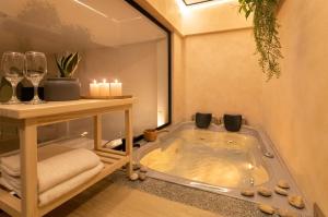 a jacuzzi tub in a room with candles and wine glasses at Amaru Suites Salento - Apartamentos con Jacuzzi y Vistas al Bosque in Salento