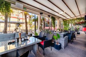 a restaurant with tables and chairs and plants at Hotel Regal in Costinesti