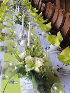 una mesa larga con velas blancas y flores verdes en Landgasthof Löwen, en Tübingen