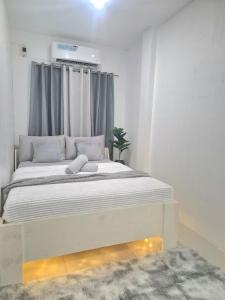 a bedroom with a large bed with grey curtains at The Lake Haus Cebu in Lapu Lapu City +24 photos