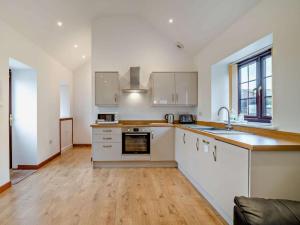 a large kitchen with white cabinets and a wooden floor at 2 Bed in Bristol oc-72837 in Chew Magna