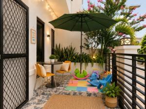 a patio with an umbrella and a table and chairs at The Lake Haus Cebu in Lapu Lapu City