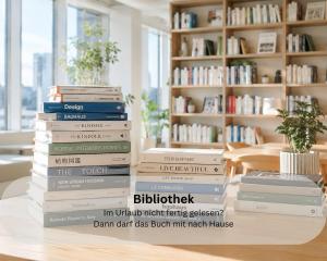 a stack of books sitting on a table at Moderne Ferienwohnung in Strandnähe - Urlaubsträume am Meer in Neue Tiefe Fehmarn