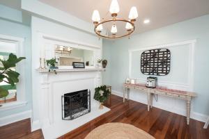 a living room with a fireplace and a chandelier at The Parrish Grove Inn in Cocoa