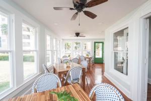 a dining room with tables and chairs and a ceiling fan at The Parrish Grove Inn in Cocoa