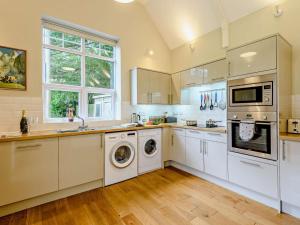a kitchen with white cabinets and a washer and dryer at 2 Bed in Blandford Forum oc-83814 in Morden