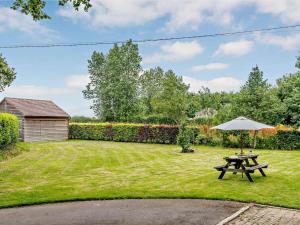 a picnic table and an umbrella in a yard at 2 Bed in Blandford Forum oc-83814 in Morden +5 photos