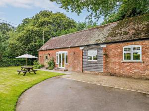 a brick house with a picnic table and an umbrella at 2 Bed in Blandford Forum oc-83814 in Morden