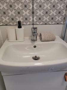 a white sink with two toiletries on top of it at CASA MINI 5 in Pécs +16 photos