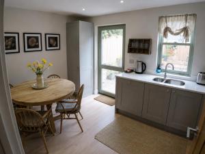 a kitchen with a table and a sink and a dining room at Storm View in Castletown