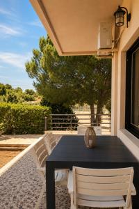 a black table and two white chairs on a patio at Sounio Garden Retreat in Panayía