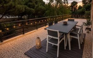 a table and chairs on a deck with lights at Sounio Garden Retreat in Panayía