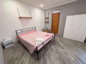 a bedroom with a bed with a pink blanket at La casa del Borgo in Cetraro