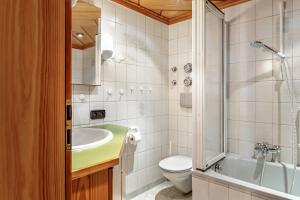 a bathroom with a tub and a toilet and a sink at Haus Schmid in Lenzkirch +130 photos