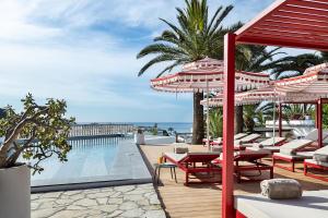 a pool with chairs and umbrellas on a deck at One Shot Buenavista in Santa Eularia des Riu