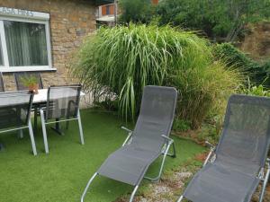 two chairs and a table in a yard with grass at CASA MINI 5 in Pécs