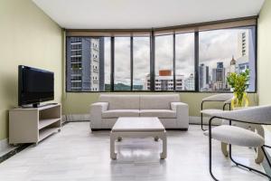 a living room with a couch and a tv at Torres de Alba Hotel & Suites in Panama City